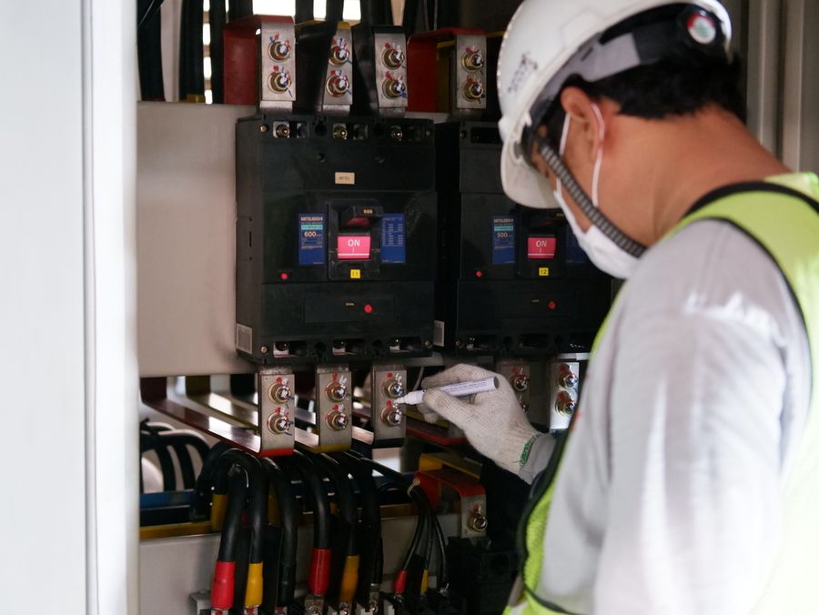 受変電設備のブレーカーを点検する作業員